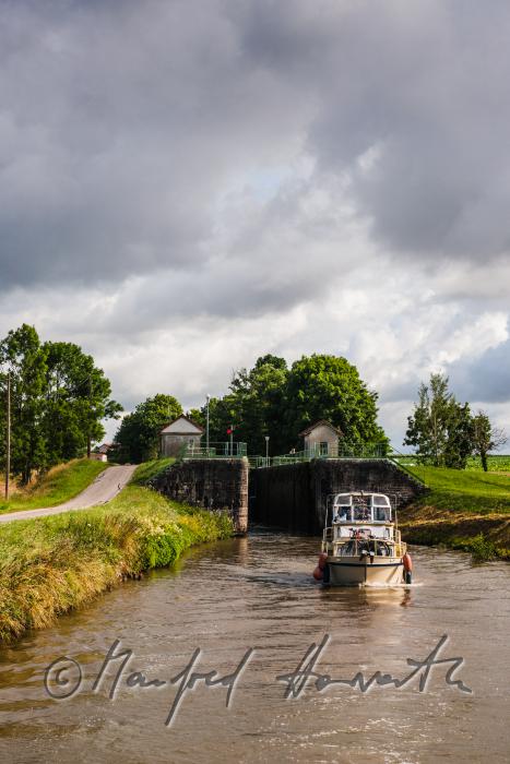 house boat leaving the lock of the town of Rully