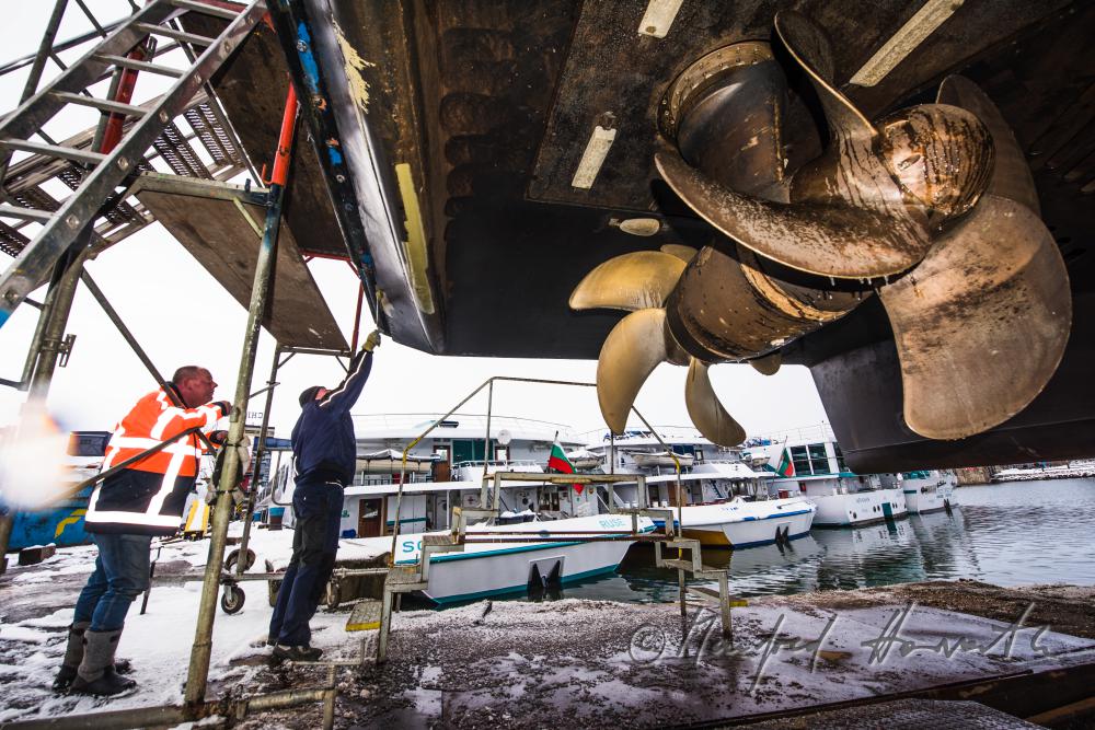 painting a ship in the drydock of the wharf
