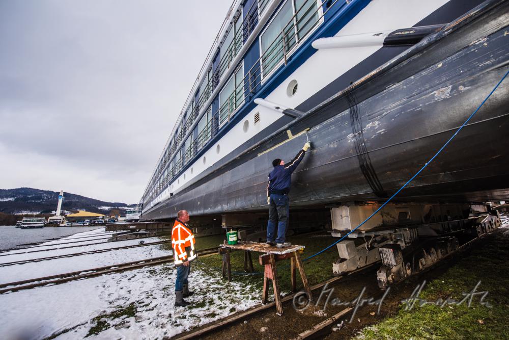 painting a ship in the drydock of the wharf