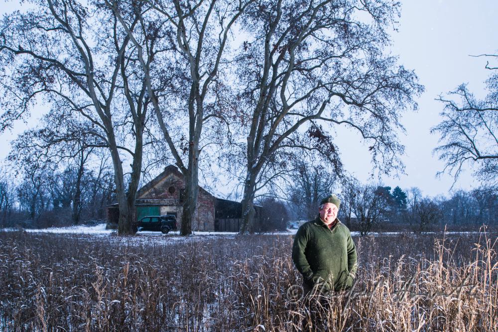 hunter in a cropfield near the farmhouse
