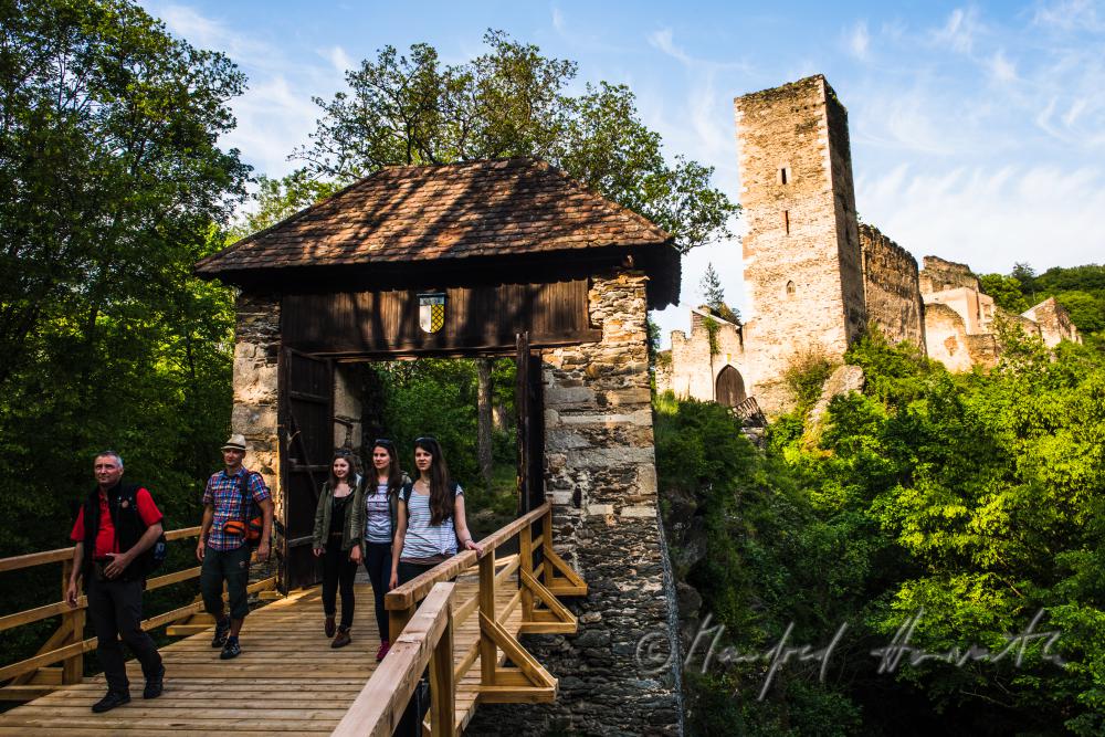 medieval Castle Kaja and hikers on the bridge