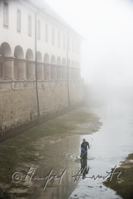 fishermen seeking for trout in the ditch of the monastery