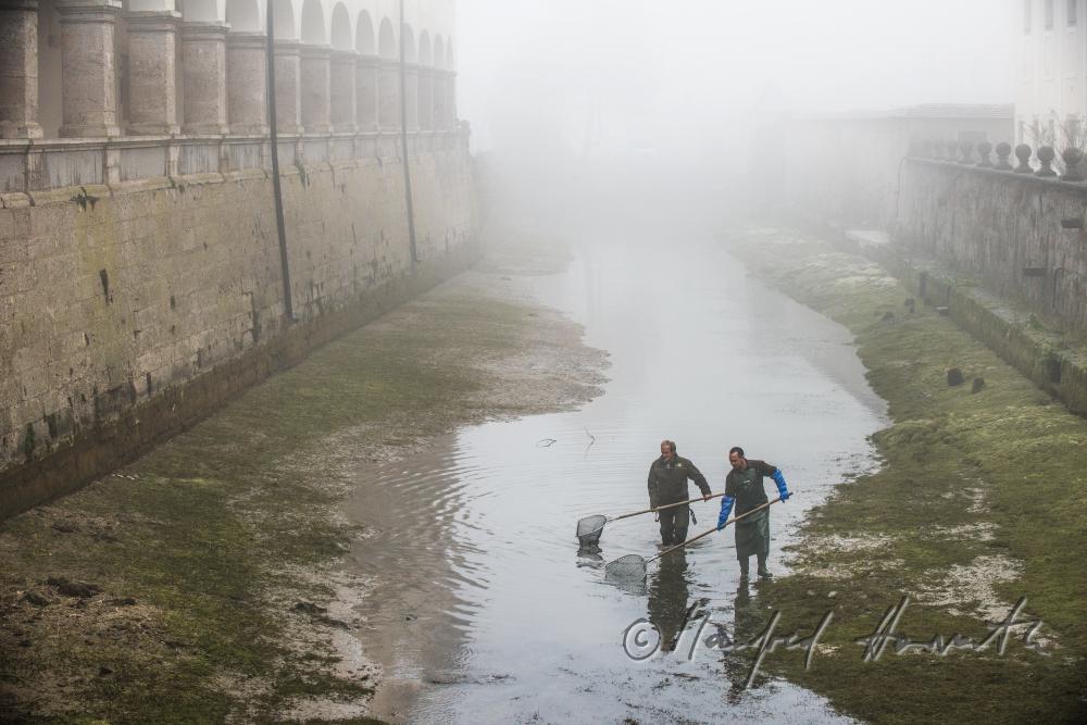 fishermen seeking for trout in the ditch of the monastery