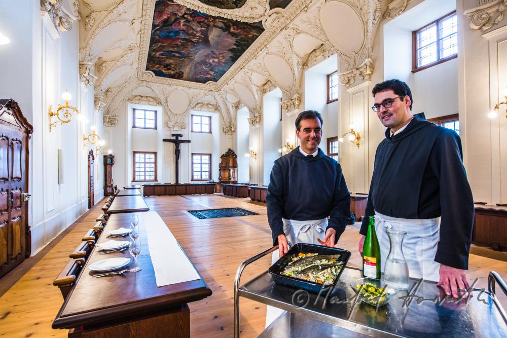 monks in the dining hall with a fish dish