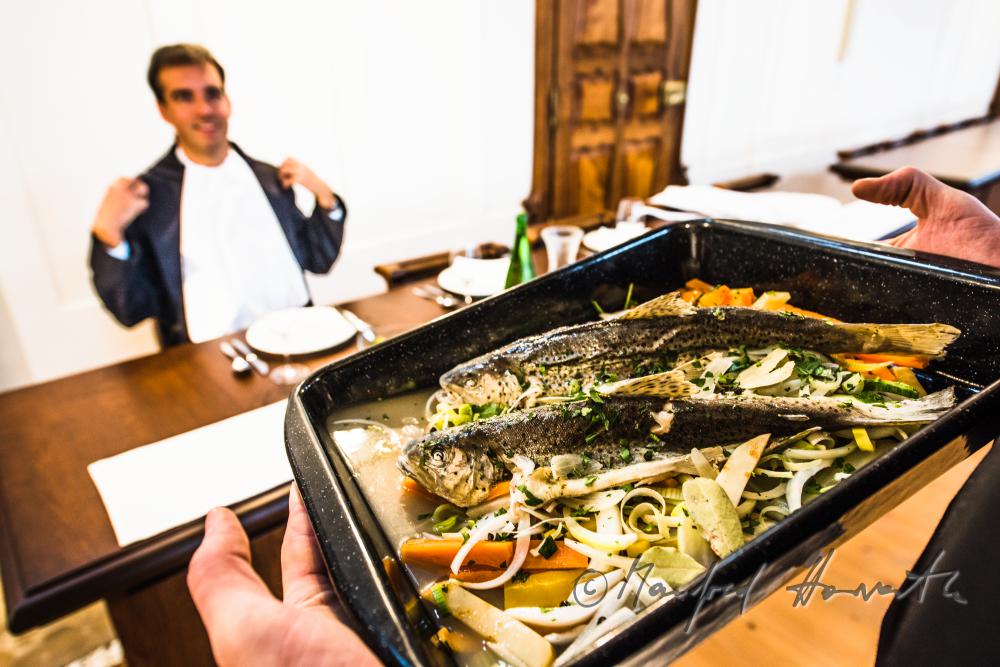 monks in the dining hall with a fish dish