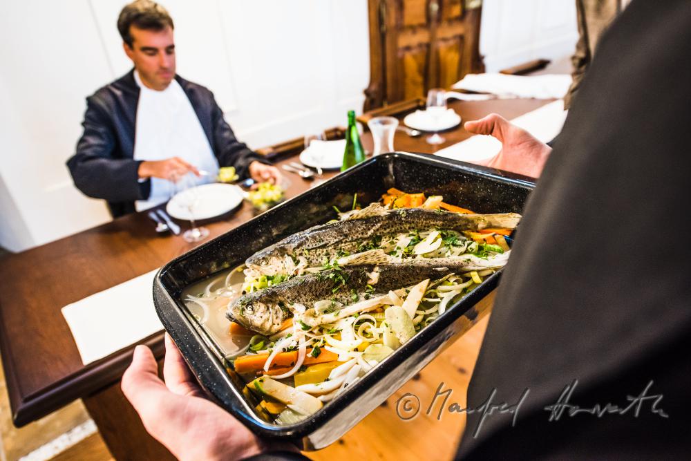 monks in the dining hall with a fish dish