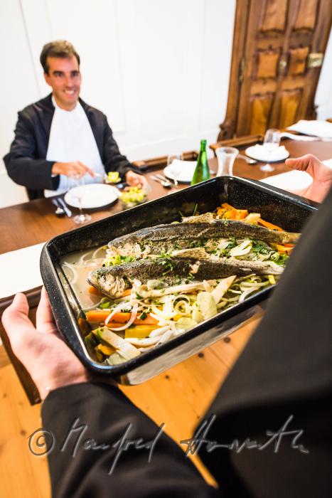 monks in the dining hall with a fish dish