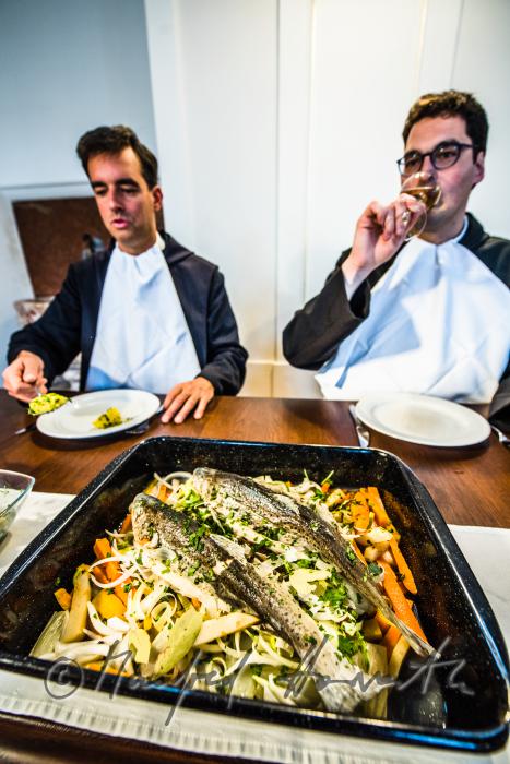 monks in the dining hall with a fish dish