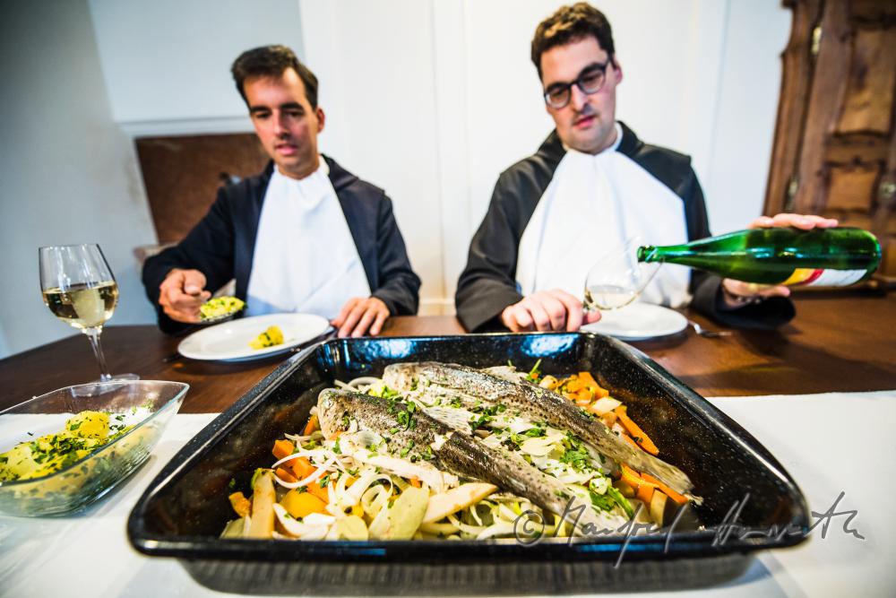 monks in the dining hall with a fish dish