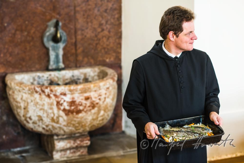 monk in the dining hall with a fish dish