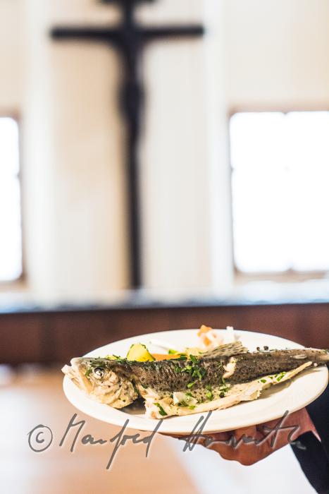 monk in the dining hall with a fish dish