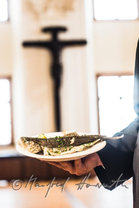 monk in the dining hall with a fish dish
