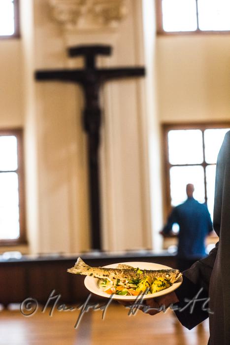 monk in the dining hall with a fish dish
