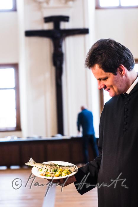 monk in the dining hall with a fish dish
