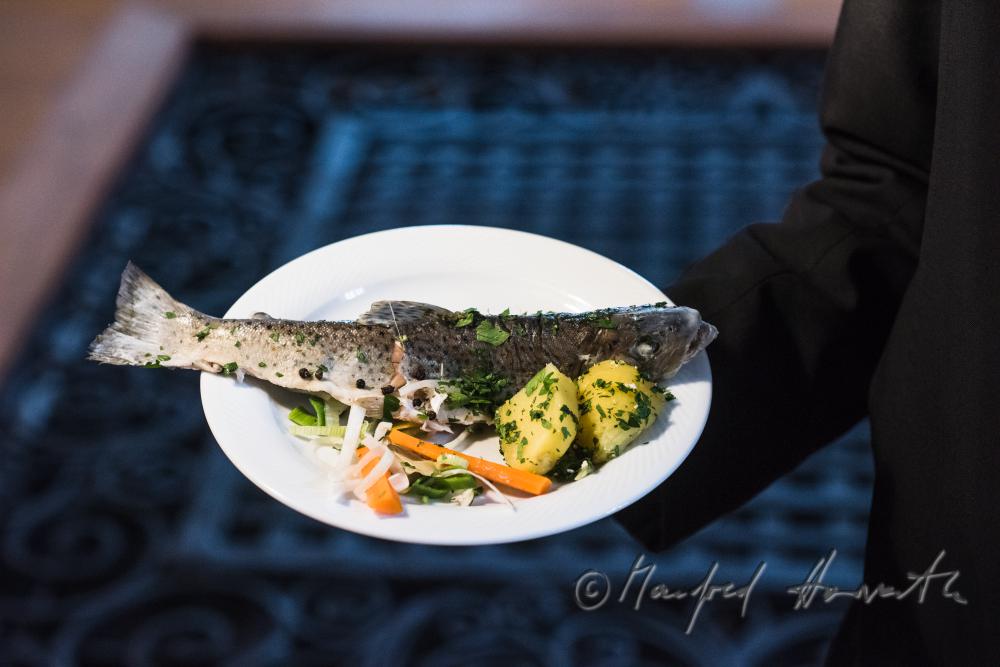 monk in the dining hall with a fish dish