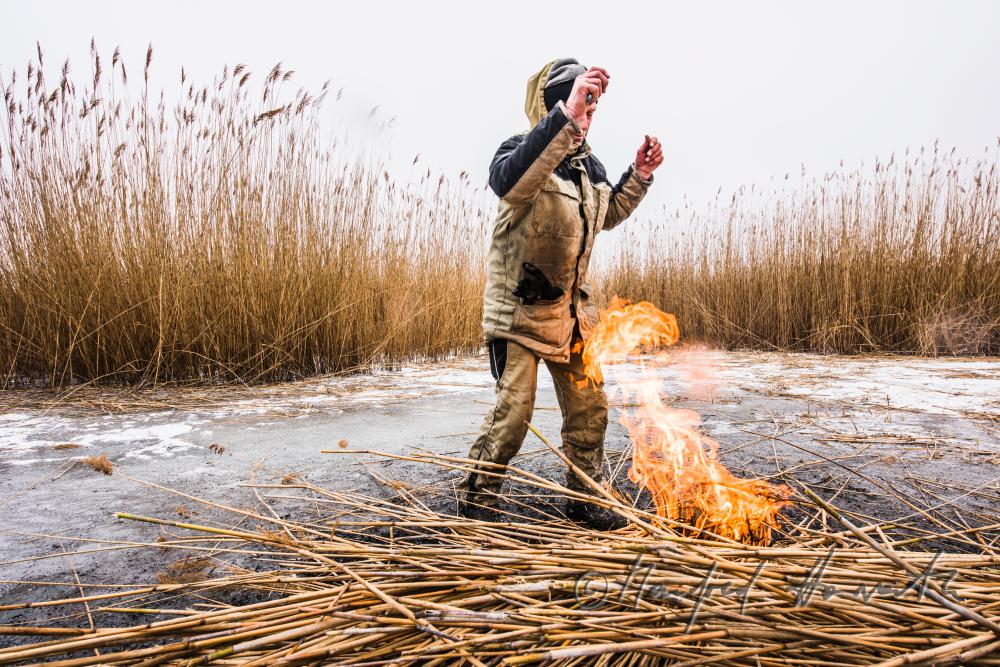 picket-worker warming up on burning reed