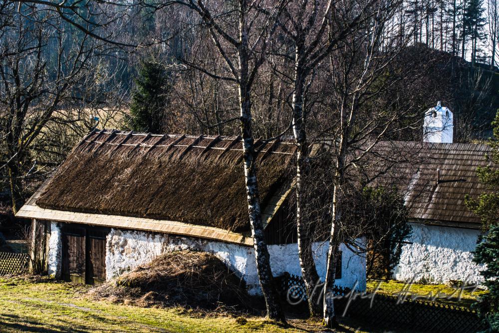 farmhouse with clay plaster and thatched roof
