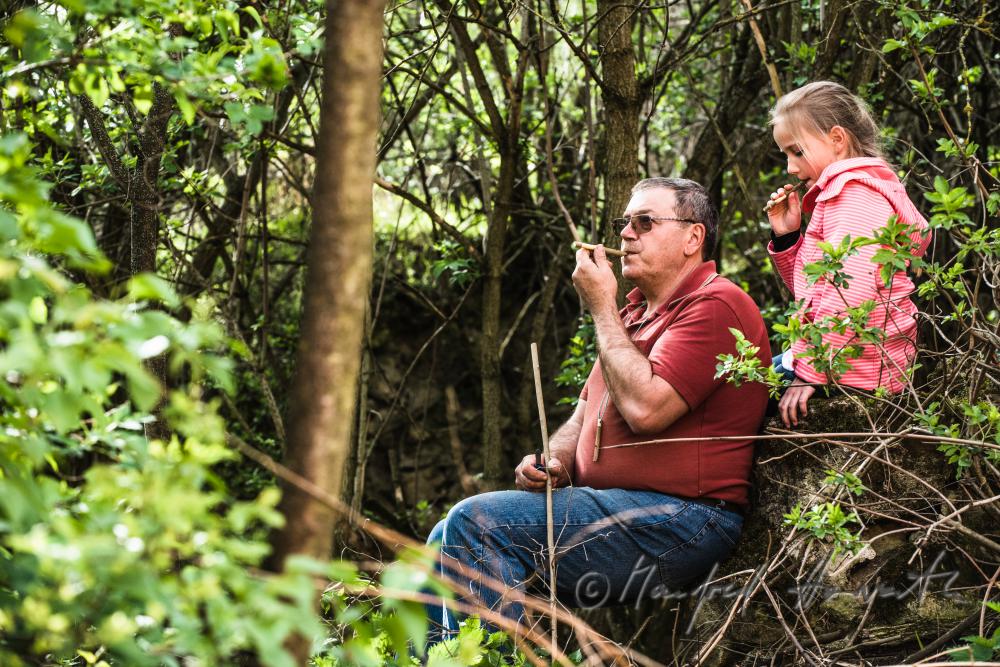 grandpa and grandchild playing with their selfmade whistle
